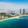 Taxe turistice Barcelona – vedere aeriană asupra plajei Barceloneta și skyline-ul orașului