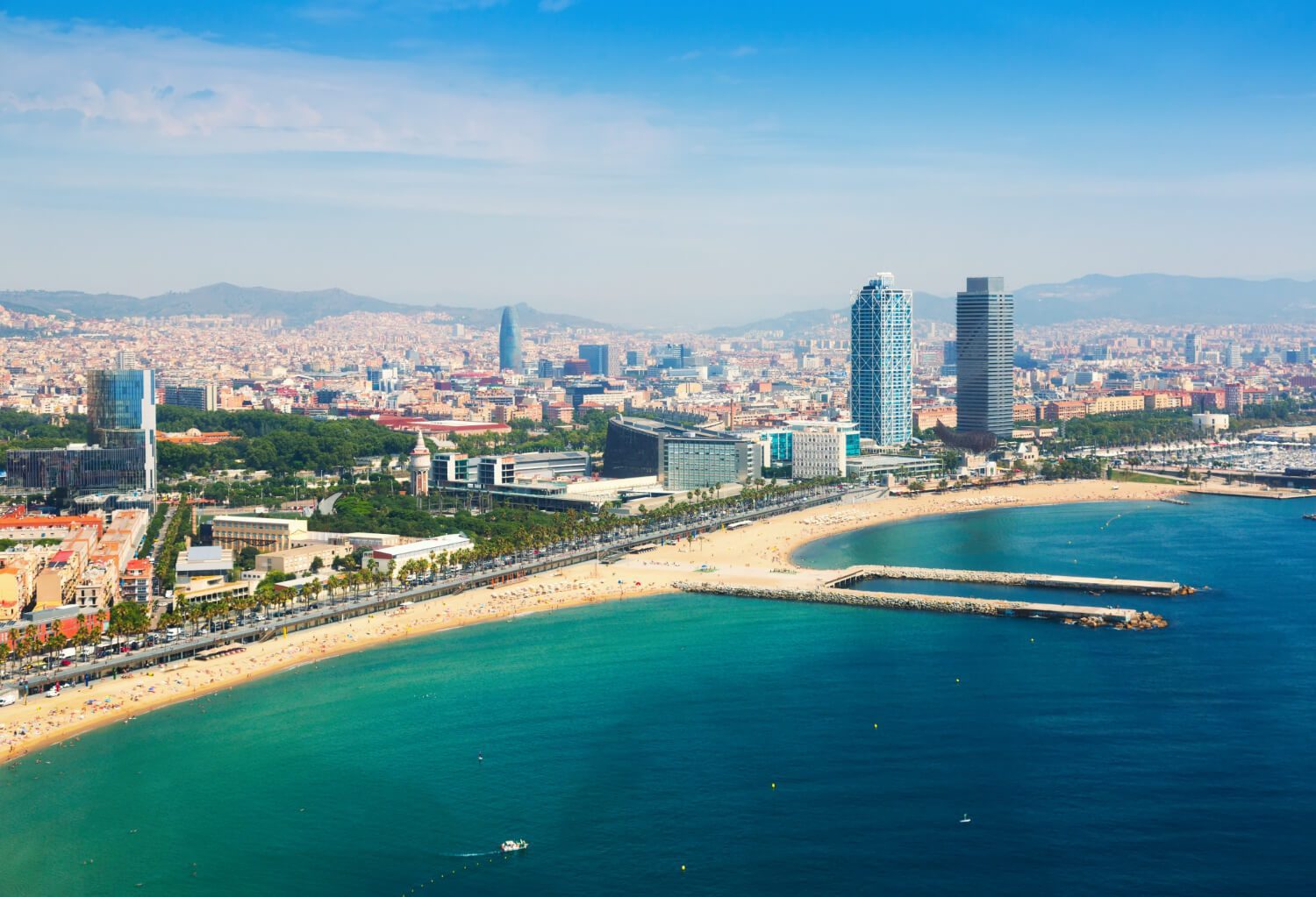 Taxe turistice Barcelona – vedere aeriană asupra plajei Barceloneta și skyline-ul orașului