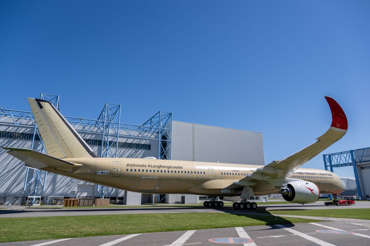 Airbus A350-1000ULR pentru Qantas Project Sunrise în fața hangarul din Toulouse cu grundul auriu de protecție înainte de vopsire aprilie 2026