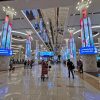 Interiorul terminalului Aeroportului Internațional Dubai DXB cu coloane LED și pasageri, hub aerian afectat de restricțiile pentru companiile aeriene străine în 2026