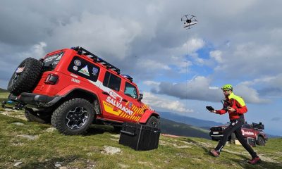 Salvamontist operând o dronă lângă un vehicul Salvamont, ilustrând siguranța pe munte
