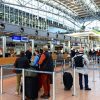 Bagaje de mână și trolere ale pasagerilor aerieni la check-in, într-un terminal de aeroport