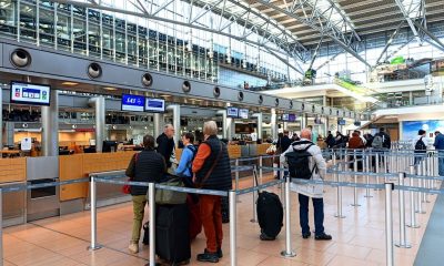 Bagaje de mână și trolere ale pasagerilor aerieni la check-in, într-un terminal de aeroport
