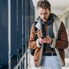 Pasager într-un aeroport folosind aplicația GoVola pe telefon pentru căutarea zborurilor