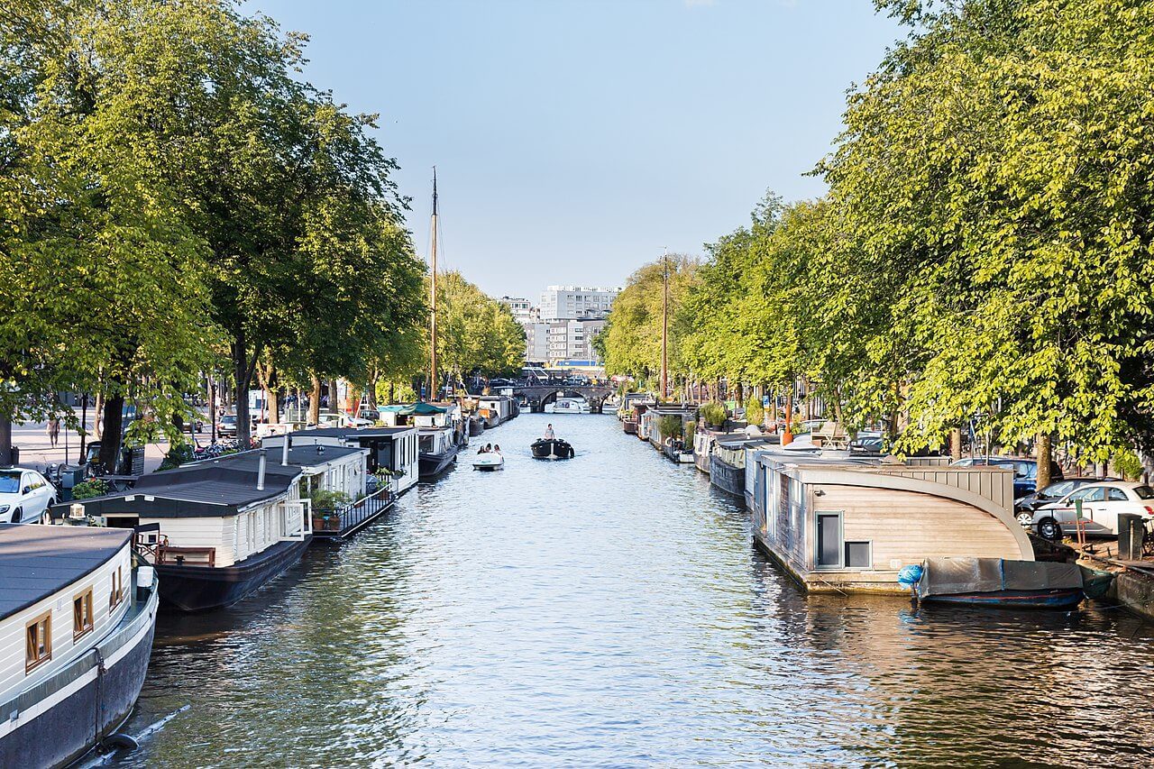 Canal Prinsengracht din Amsterdam cu case plutitoare și bărci, destinație city break Europa 2026