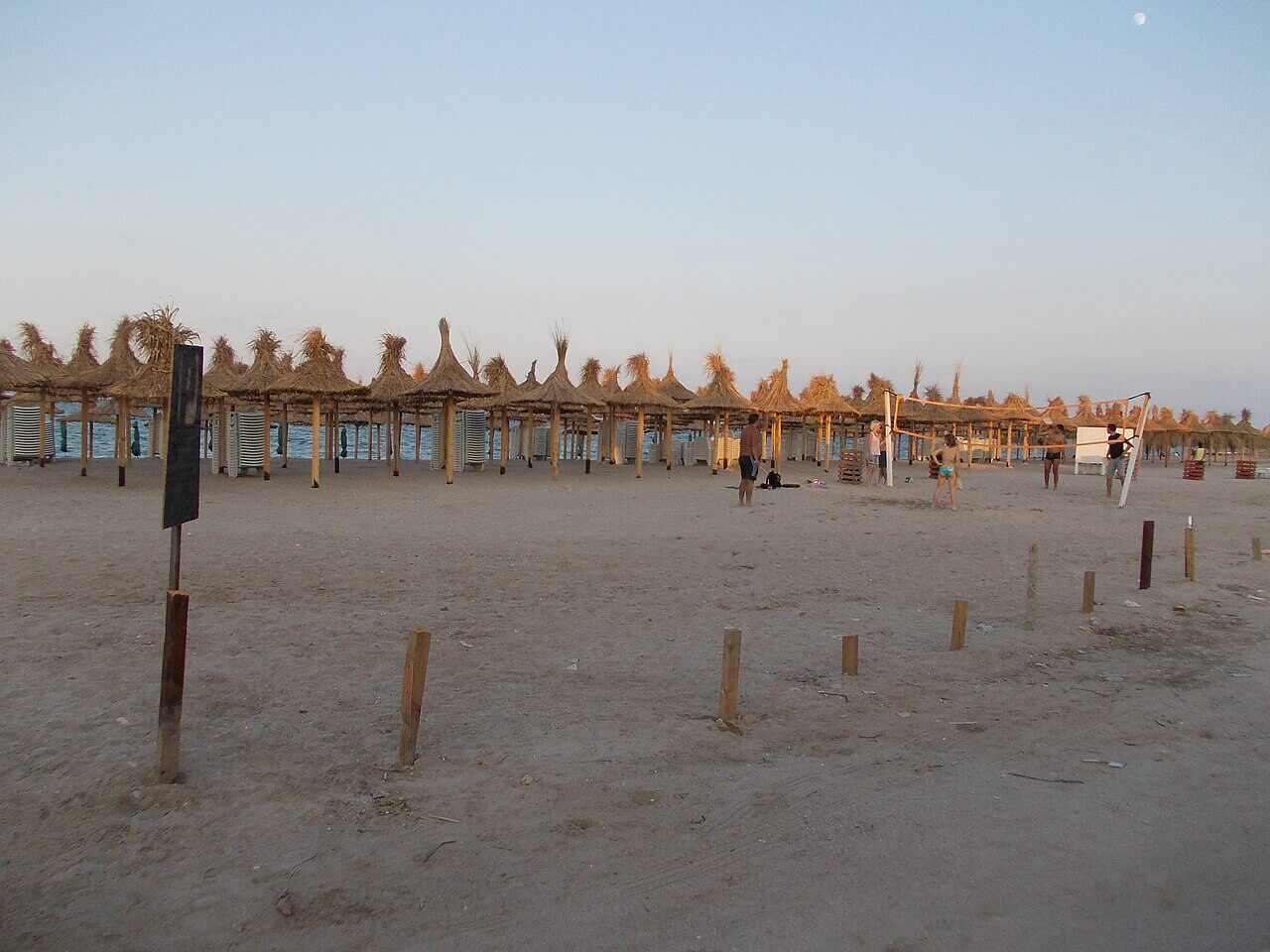 Plajă aproape goală cu umbrele de stuf pe litoralul românesc, minivacanța de Rusalii 2026
