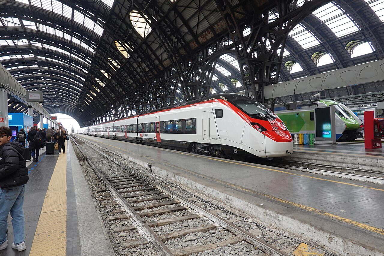 Bilet unic tren Europa: pasageri pe peronul gării Milano Centrale