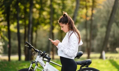Tânără în pauză lângă bicicletă pe un traseu de cicloturism din România, printre copaci