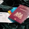 Pașaport, carte de îmbarcare și carduri bancare pe un bagaj, ilustrând procedura pentru obținerea unui titlu de călătorie