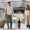 Copil ținut de mână de ambii părinți, cu bagaje, într-un terminal de aeroport, înainte de controlul de frontieră – acte necesare pentru ieșirea din țară a unui minor