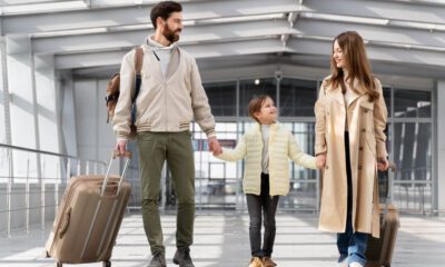 Copil ținut de mână de ambii părinți, cu bagaje, într-un terminal de aeroport, înainte de controlul de frontieră – acte necesare pentru ieșirea din țară a unui minor