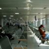 Pasageri care așteaptă în zona porților de îmbarcare a unui aeroport, cu rânduri de scaune goale — despăgubiri zbor întârziat conform Regulamentului 261/2004