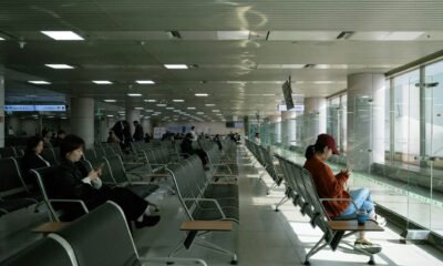 Pasageri care așteaptă în zona porților de îmbarcare a unui aeroport, cu rânduri de scaune goale — despăgubiri zbor întârziat conform Regulamentului 261/2004