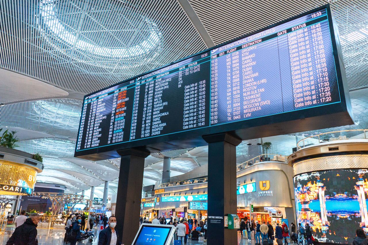Panou cu plecări internaționale într-un aeroport, imagine pentru articolul despre rambursare la un bilet de avion cumpărat prin agenție